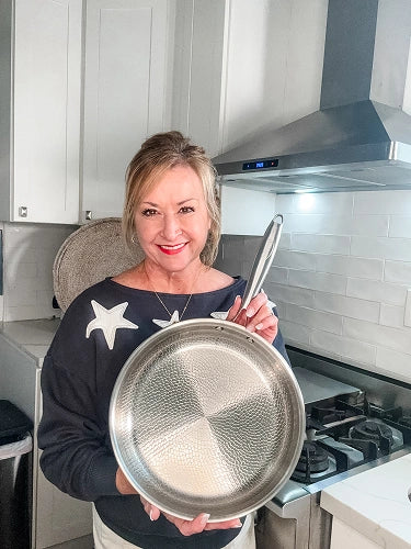 Customer displaying Siraat Titanium Hammered Pan Pro in her kitchen next to a gas range and stainless steel hood